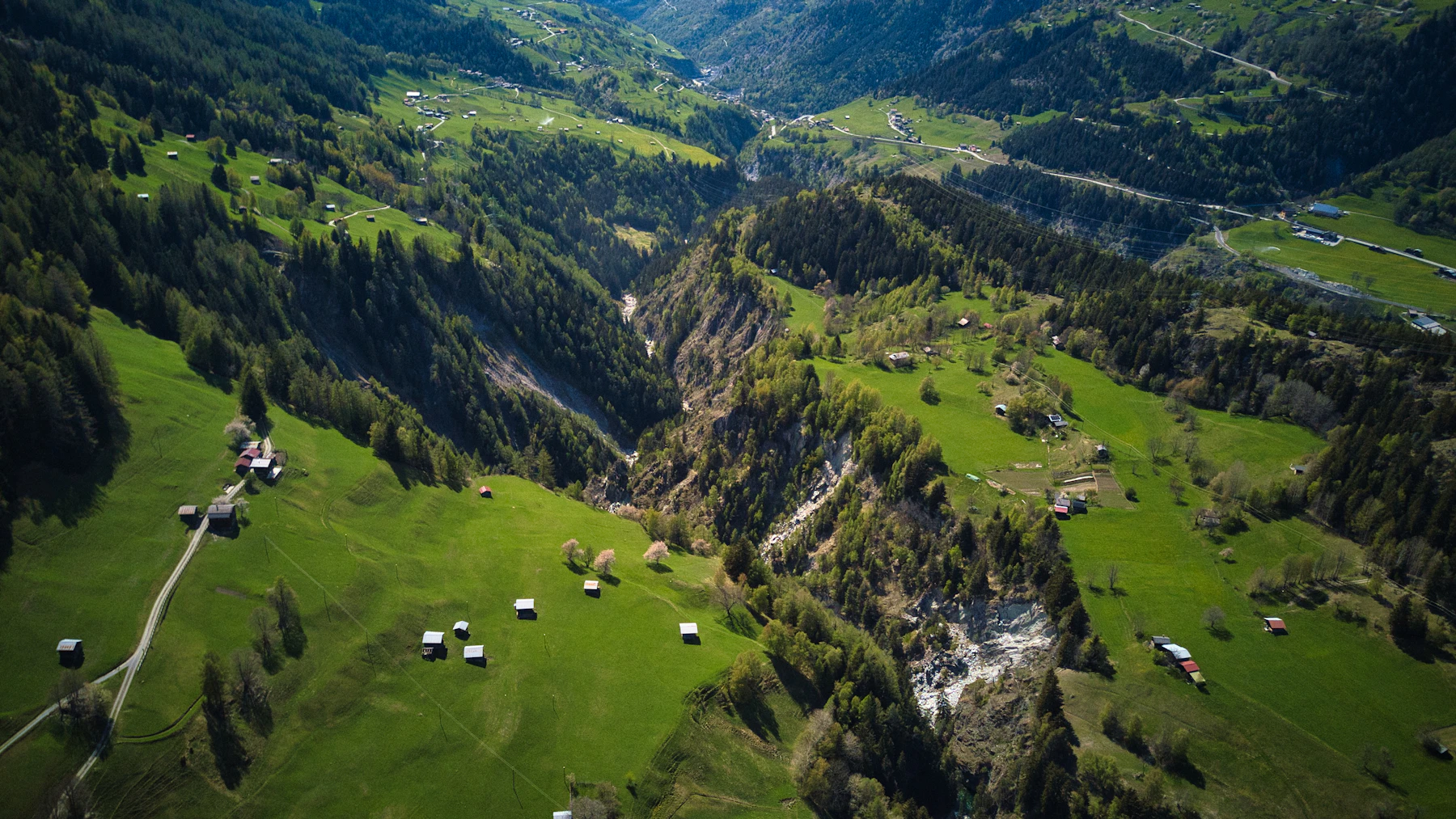 Aerial drone photograph of a green valley surrounded by mountains