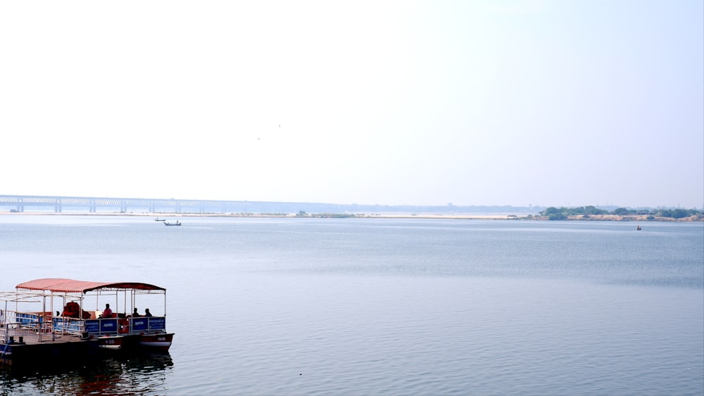 a group of people sitting on a boat in the middle of a lake