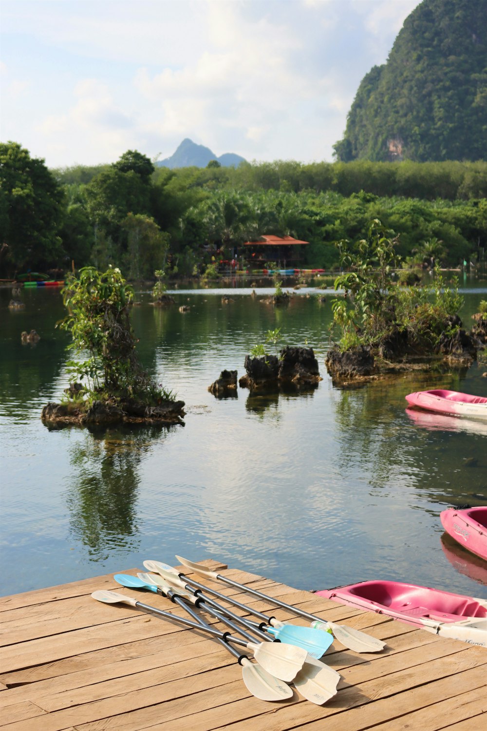 a wooden dock with kayaks and paddles on it
