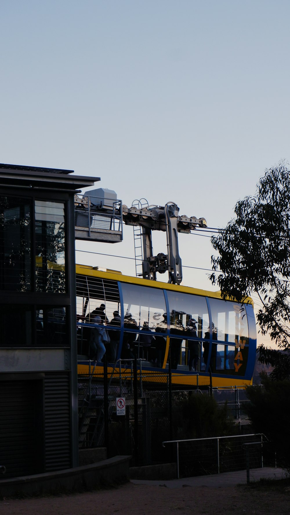a yellow and blue train traveling past a tall building