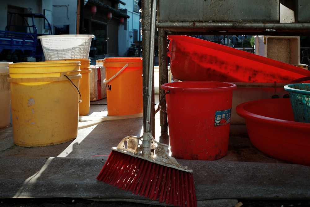 buckets and a broom sitting on the ground