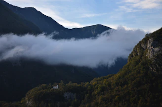 a view of a mountain with low lying clouds