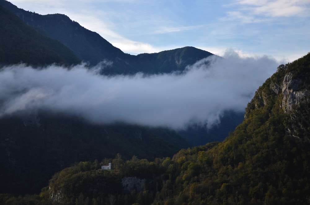 a view of a mountain with low lying clouds