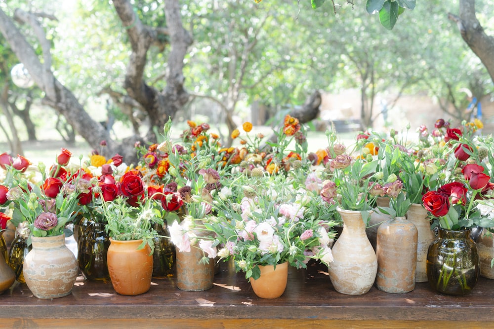 uma mesa coberta com vasos cheios de flores