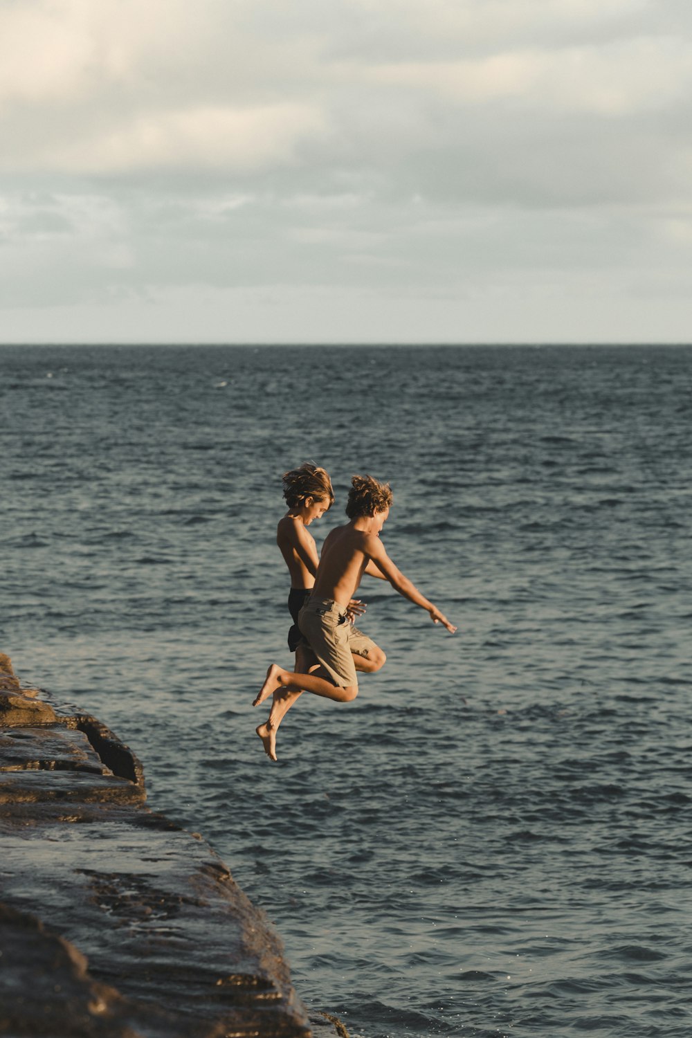 a couple of people jumping into the water