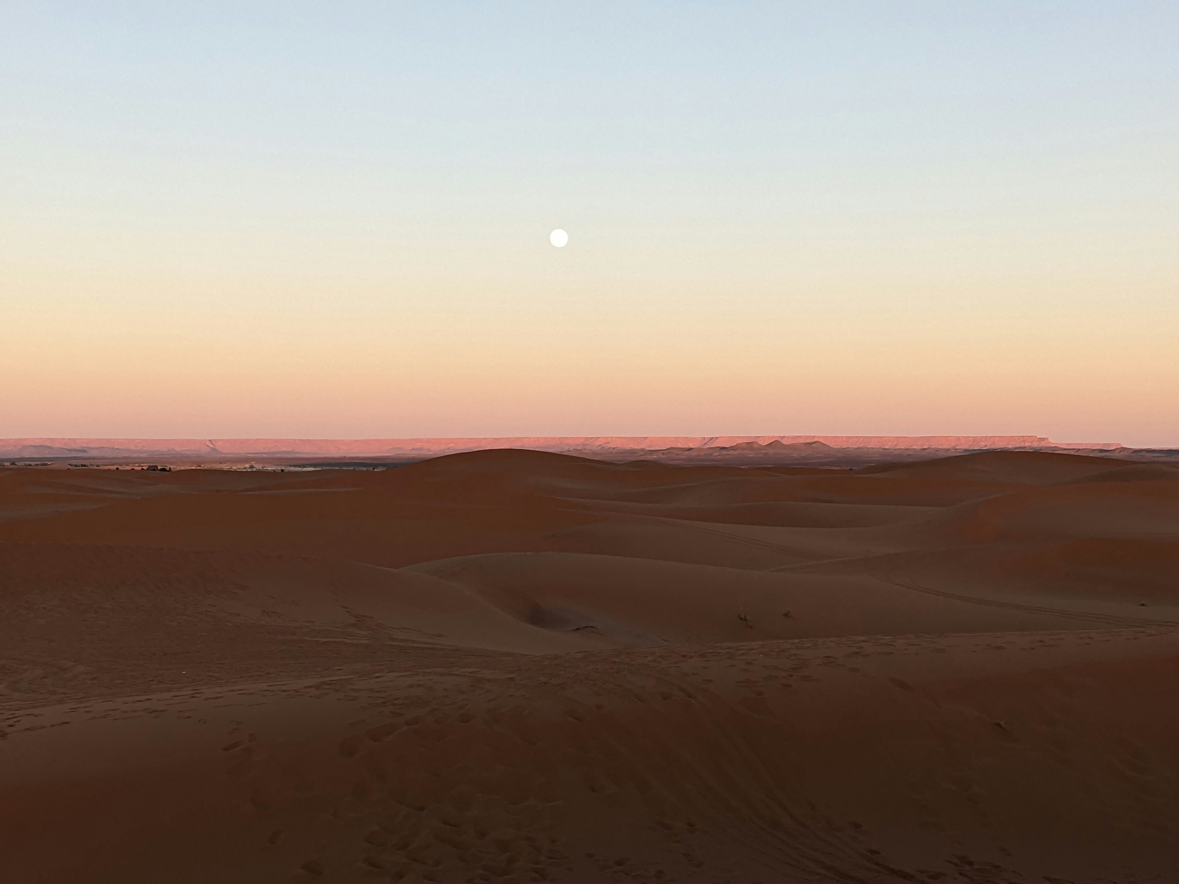 the sun is setting in the distance over the desert