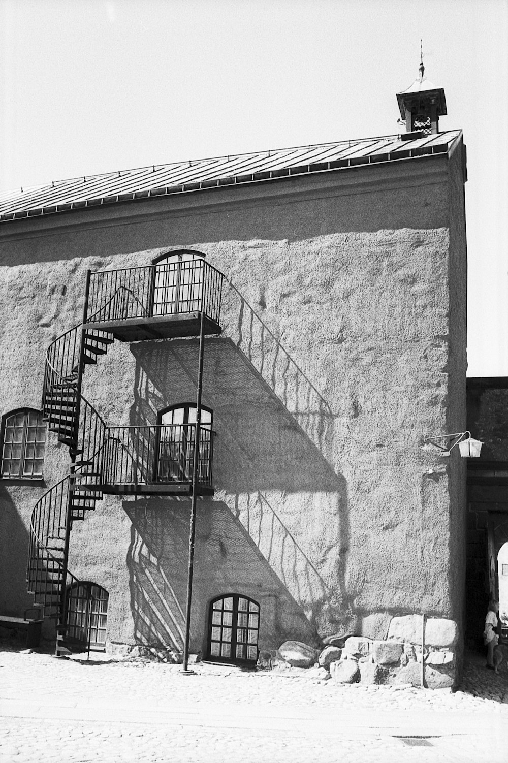 a black and white photo of a building with a spiral staircase