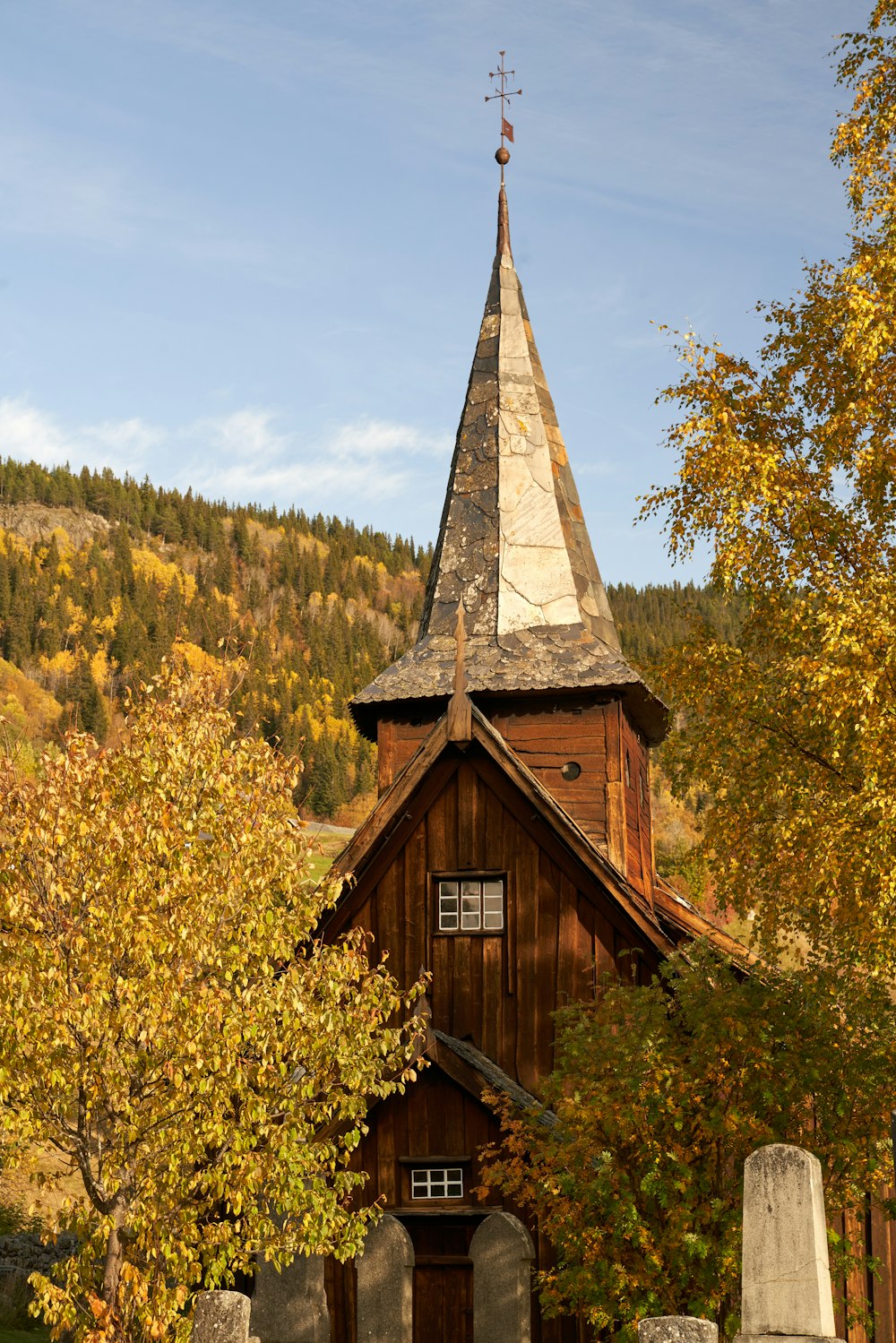 una iglesia de madera con un campanario rodeado de árboles