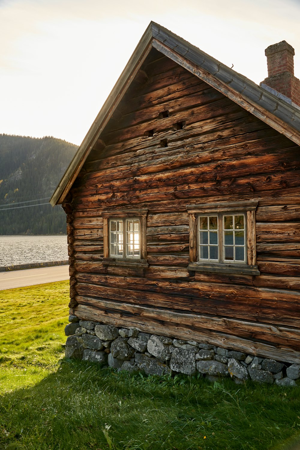 a log cabin with a stone wall and windows