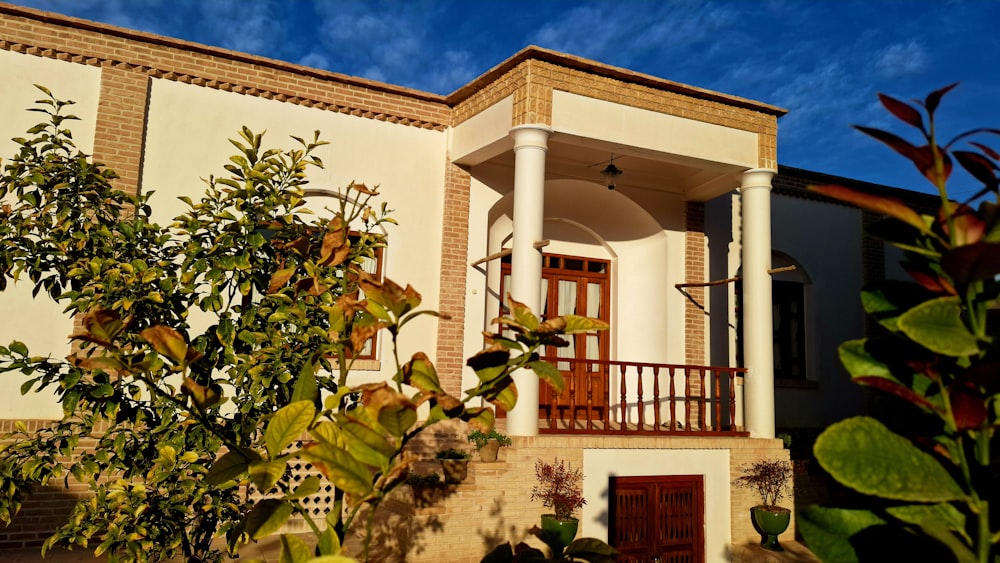 a white house with a red door and balcony