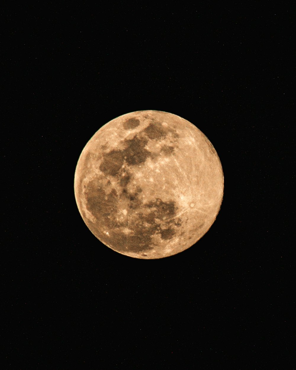 a full moon is seen in the dark sky