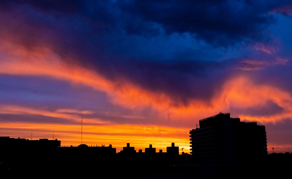 a city skyline with a colorful sunset in the background