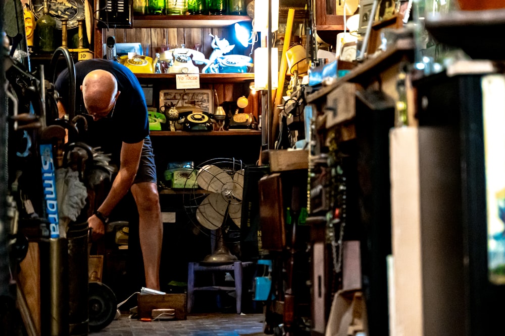 a man working on a skateboard inside of a shop