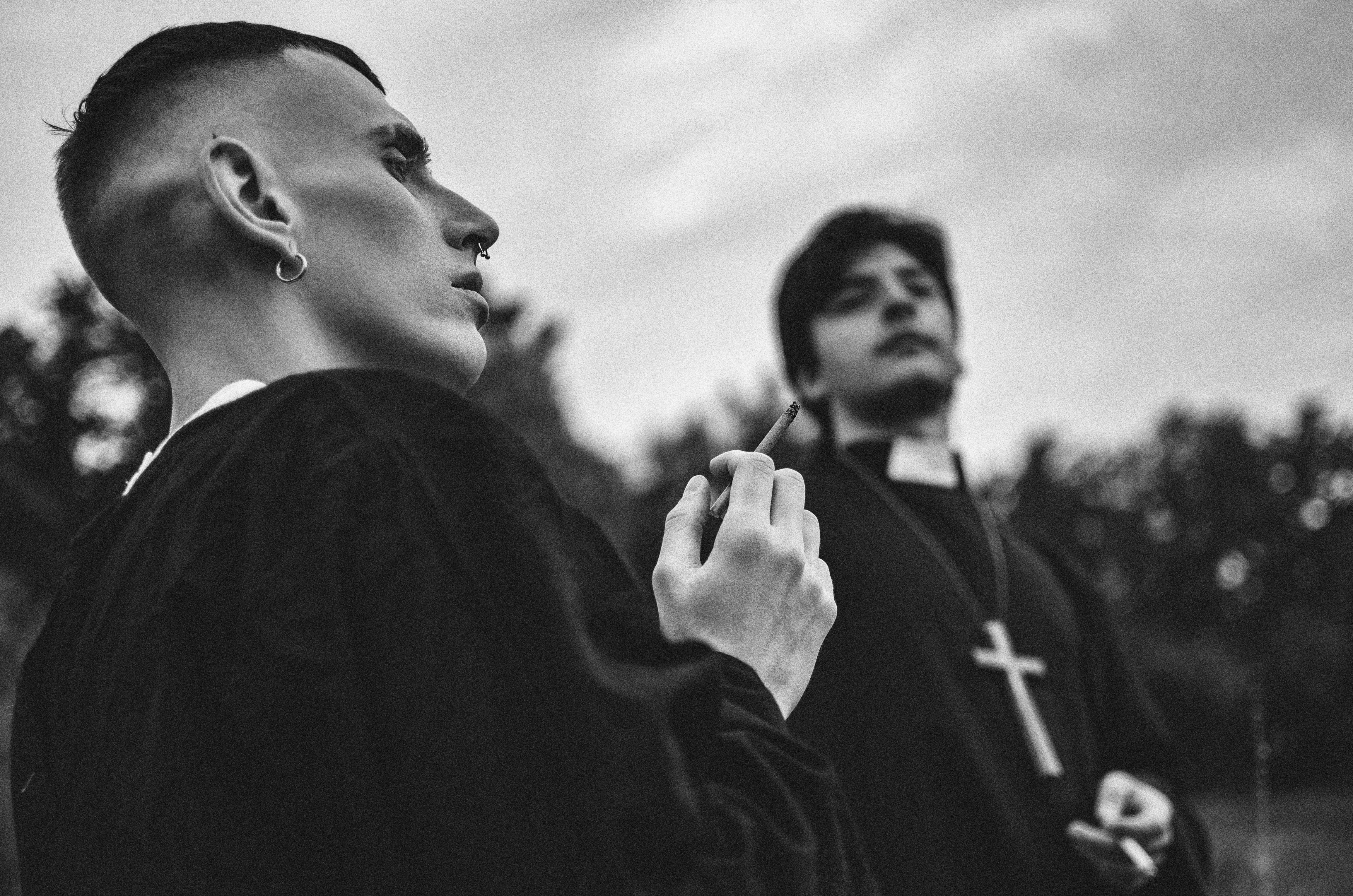 a man in a priest's robes smoking a cigarette