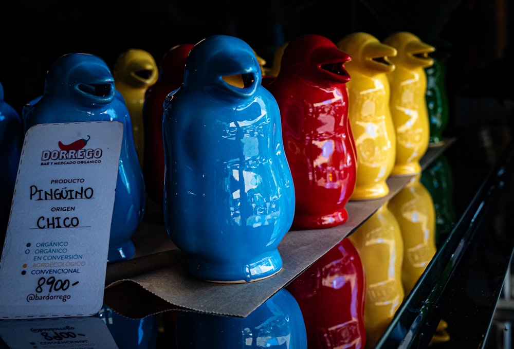 a row of colorful ceramic birds sitting on top of a shelf