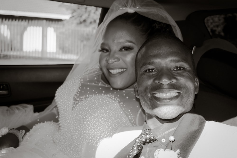 a man and a woman are smiling in a car