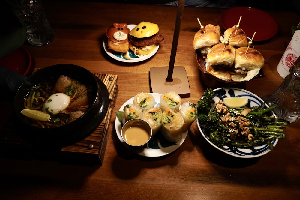 a wooden table topped with plates of food