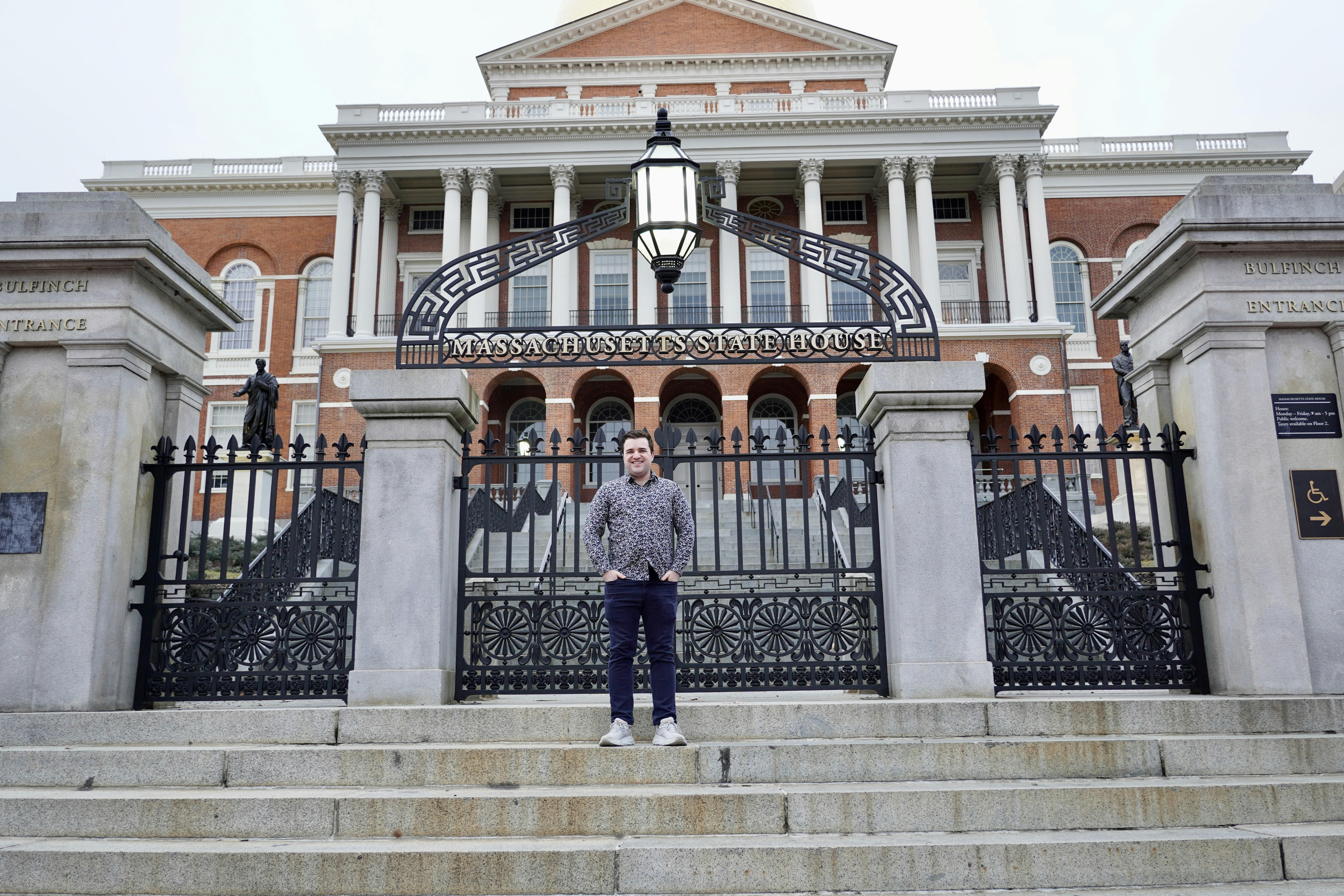 Brett Wharton stands in front of Massachusetts State House.