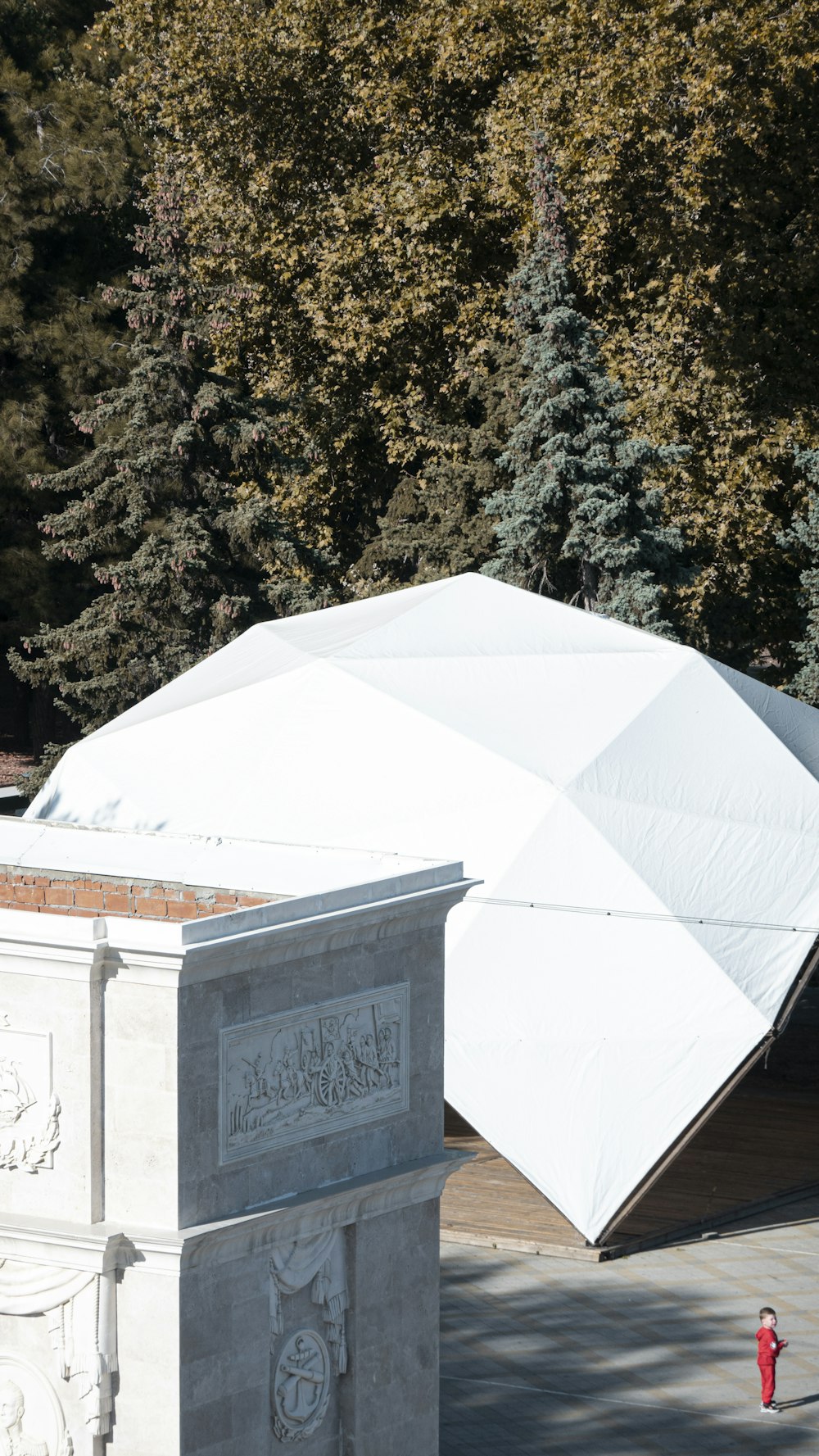 a large white umbrella sitting on top of a cement monument