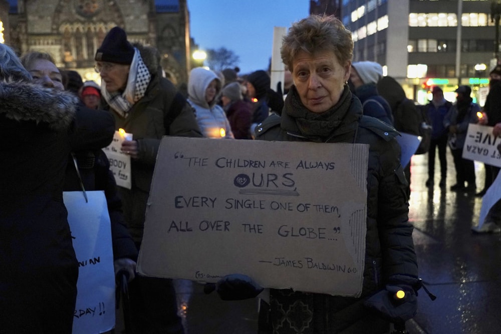 a man holding a sign in a crowd of people