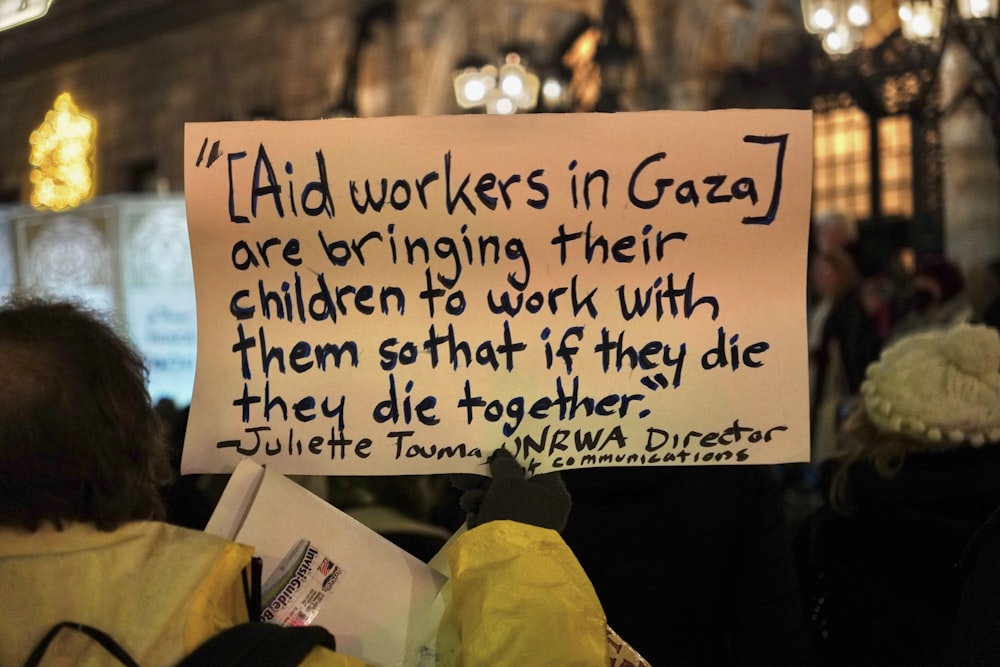 a person holding a sign in a crowd