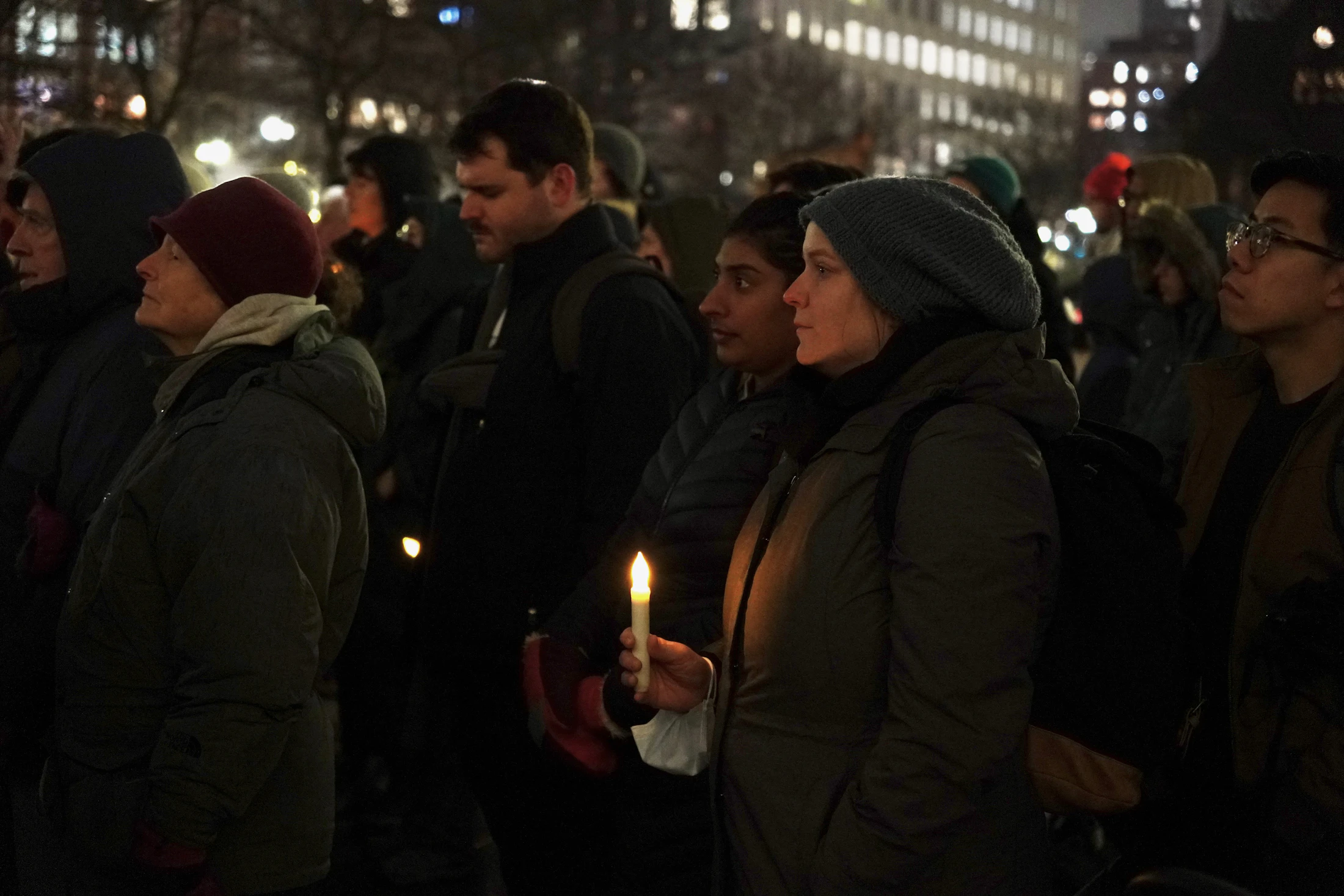 People gathered together holding candles at dusk
