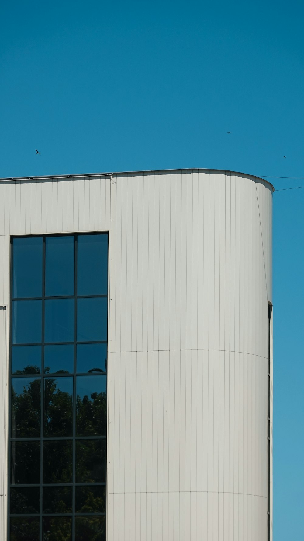 an airplane is flying over a building with a lot of windows