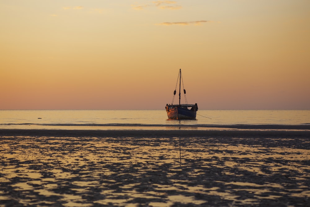 a boat sitting on top of a beach next to the ocean