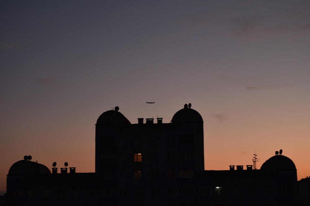 a building with a plane flying in the sky