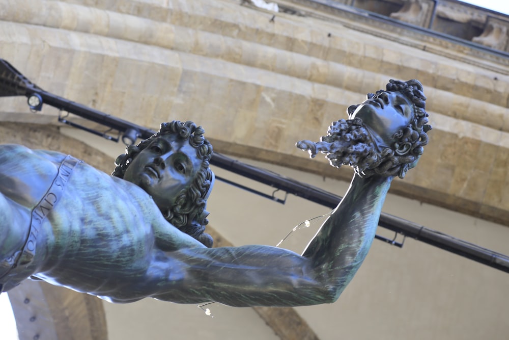 a statue of a man holding a flower in his hand