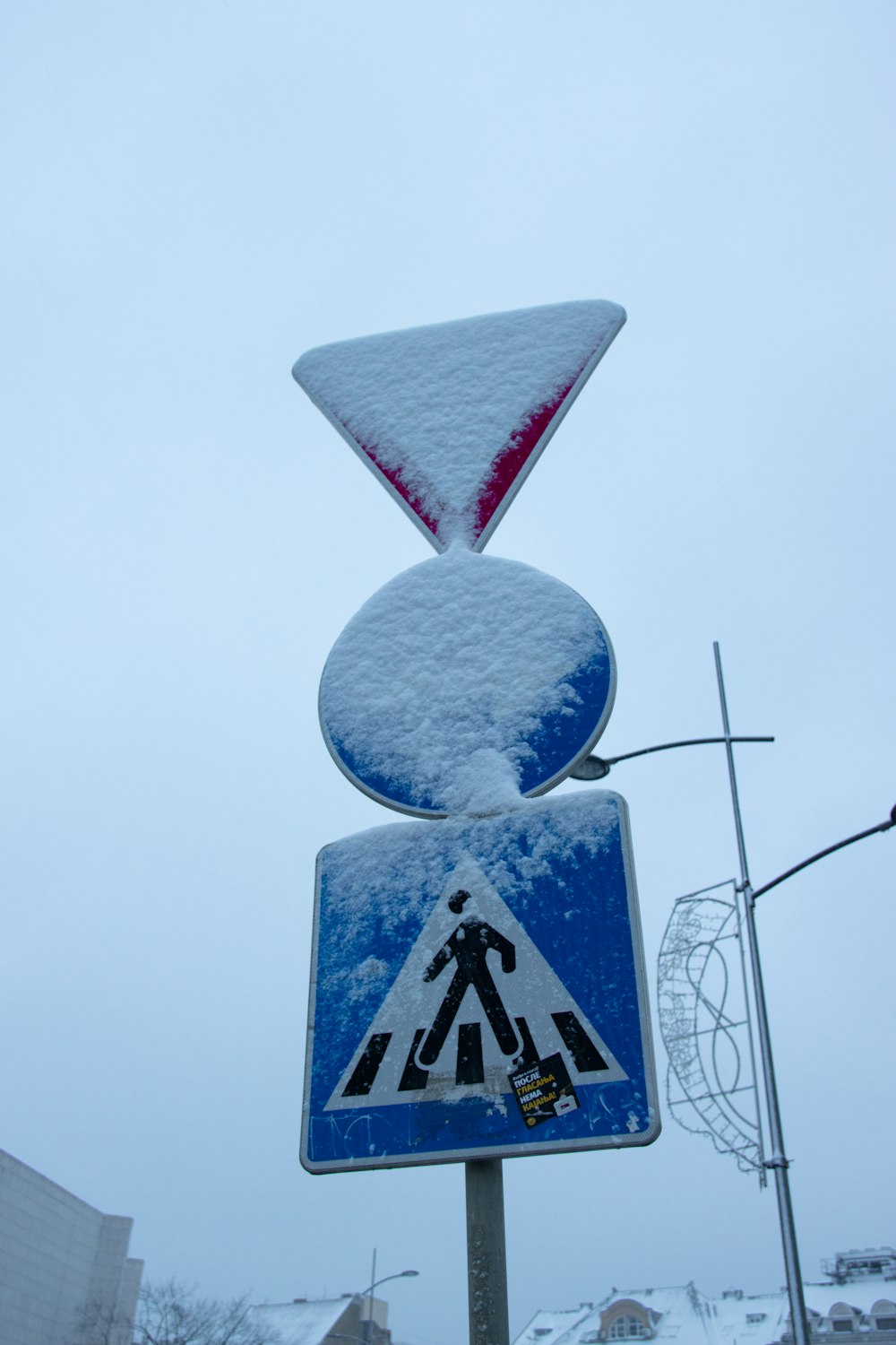 a street sign covered in snow on a pole