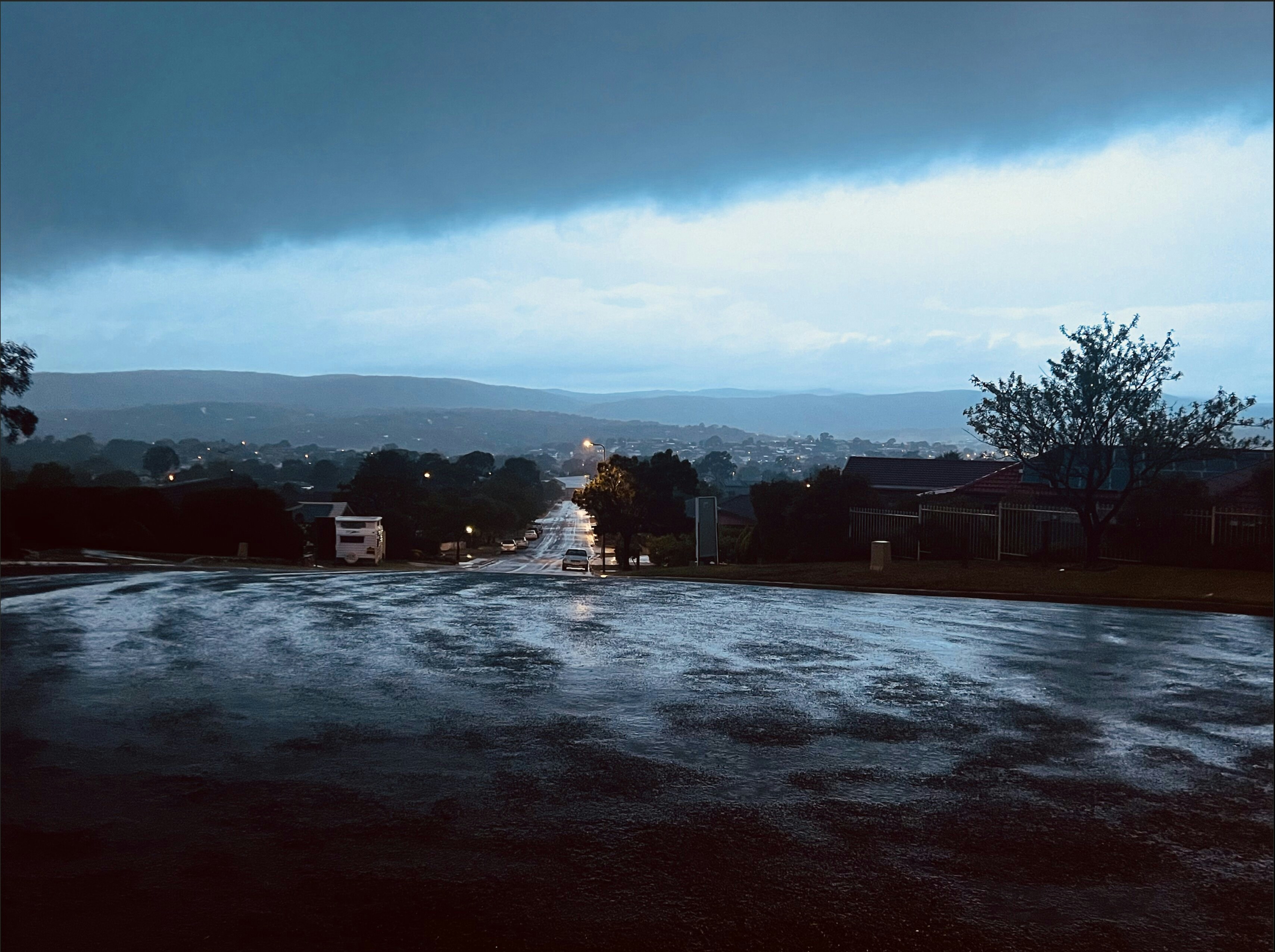 a wet street with a dark sky in the background