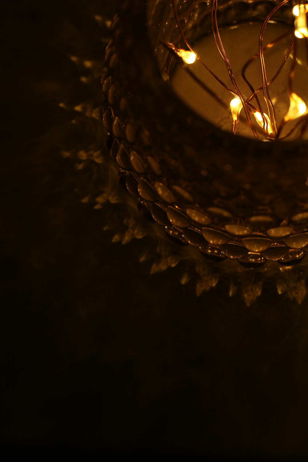 a lit candle in a basket with some lights on it