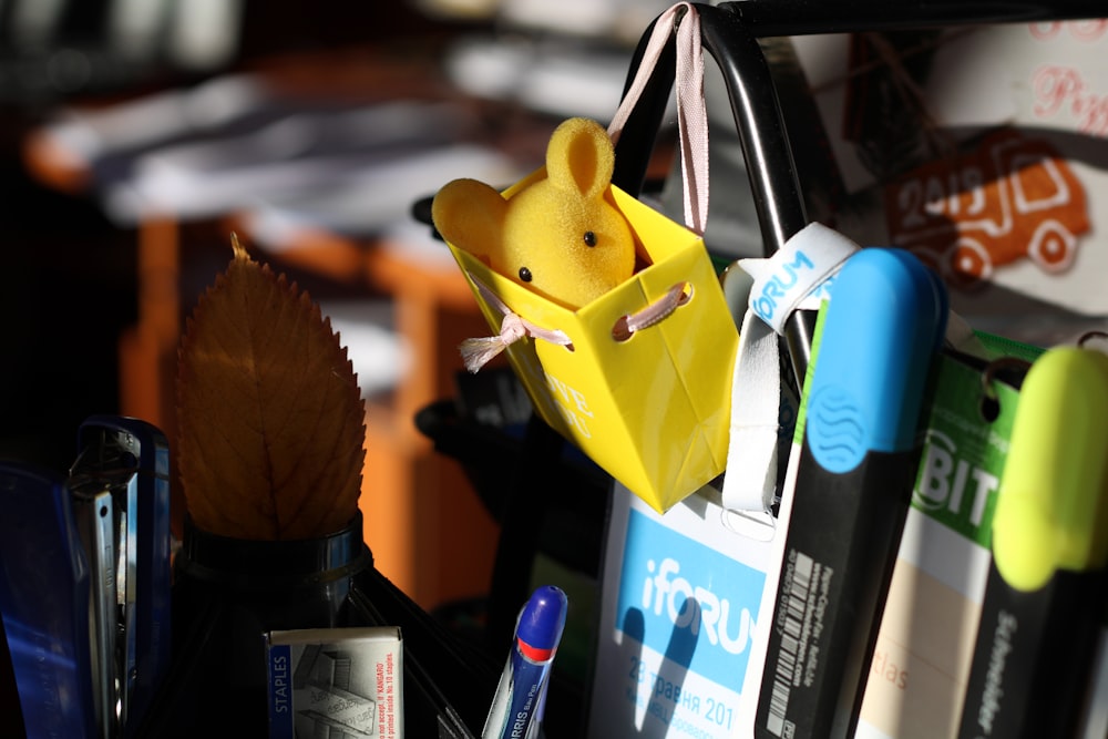 a toy mouse in a yellow bag hanging from a hook