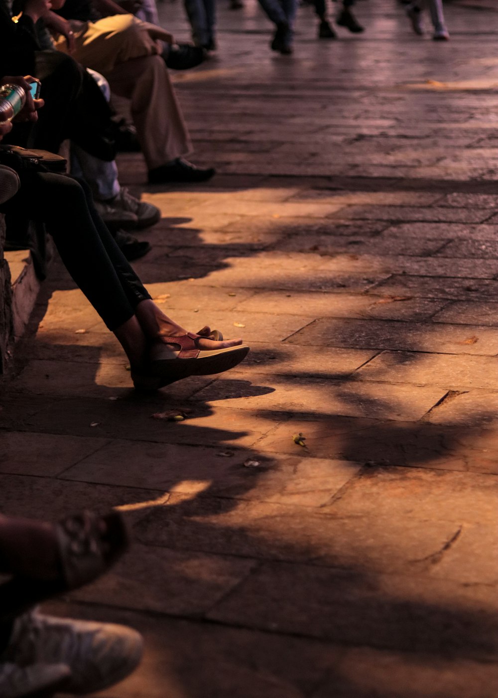 a group of people sitting next to each other on a sidewalk