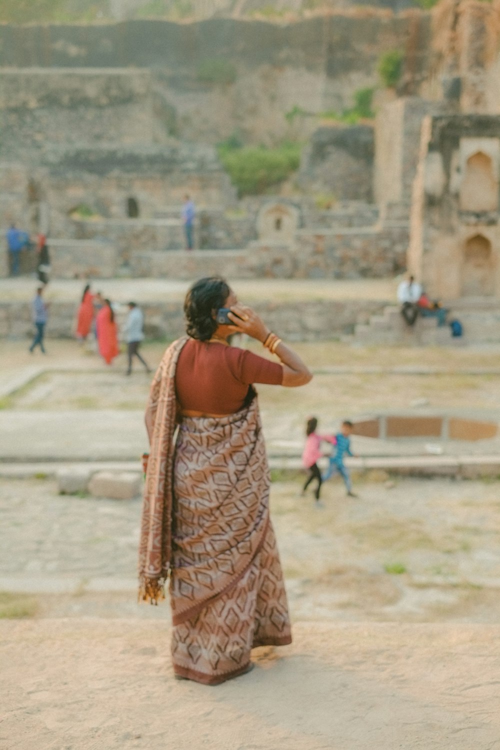 a woman in a sari talking on a cell phone