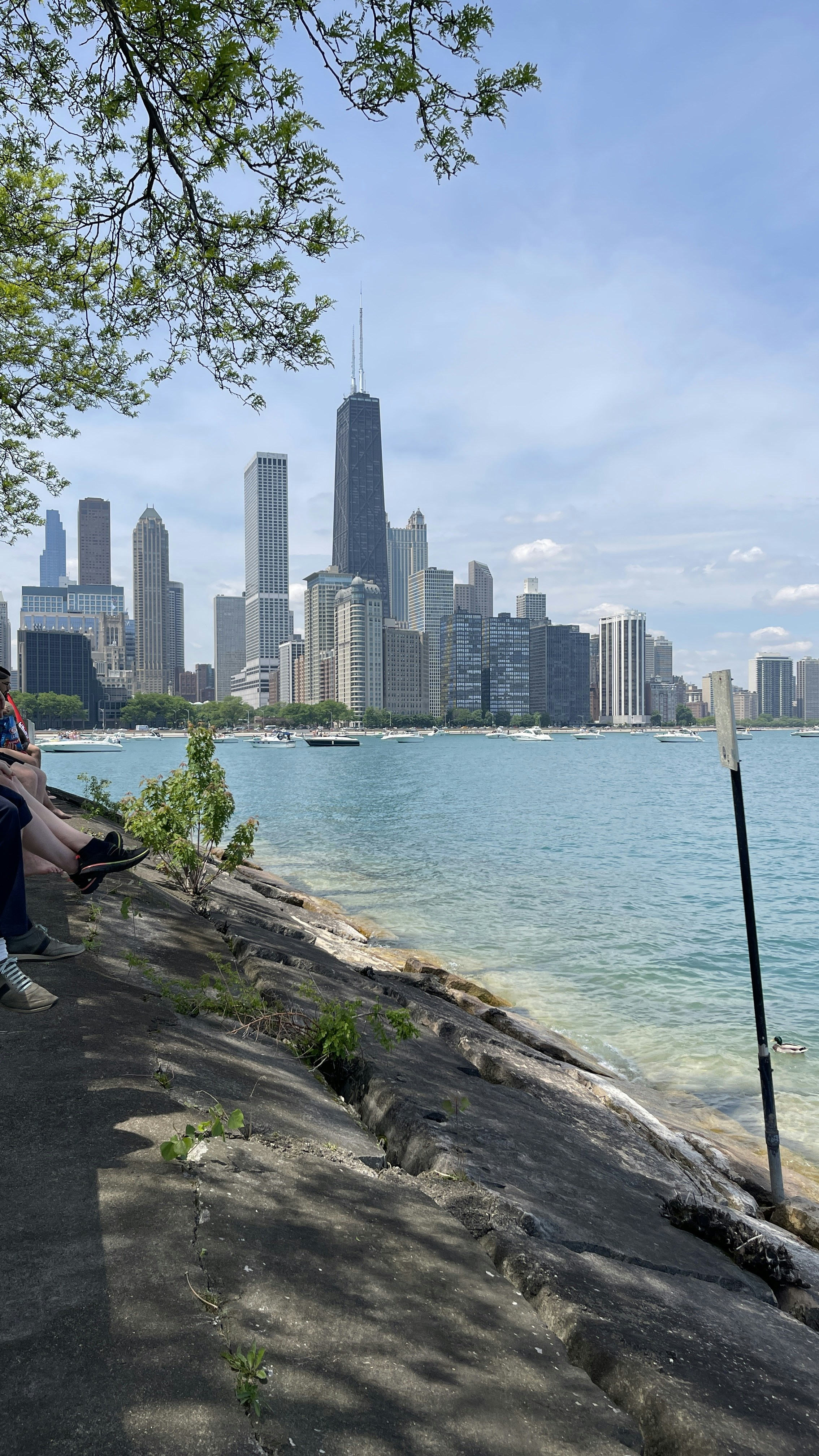 a man sitting on a bench next to a body of water