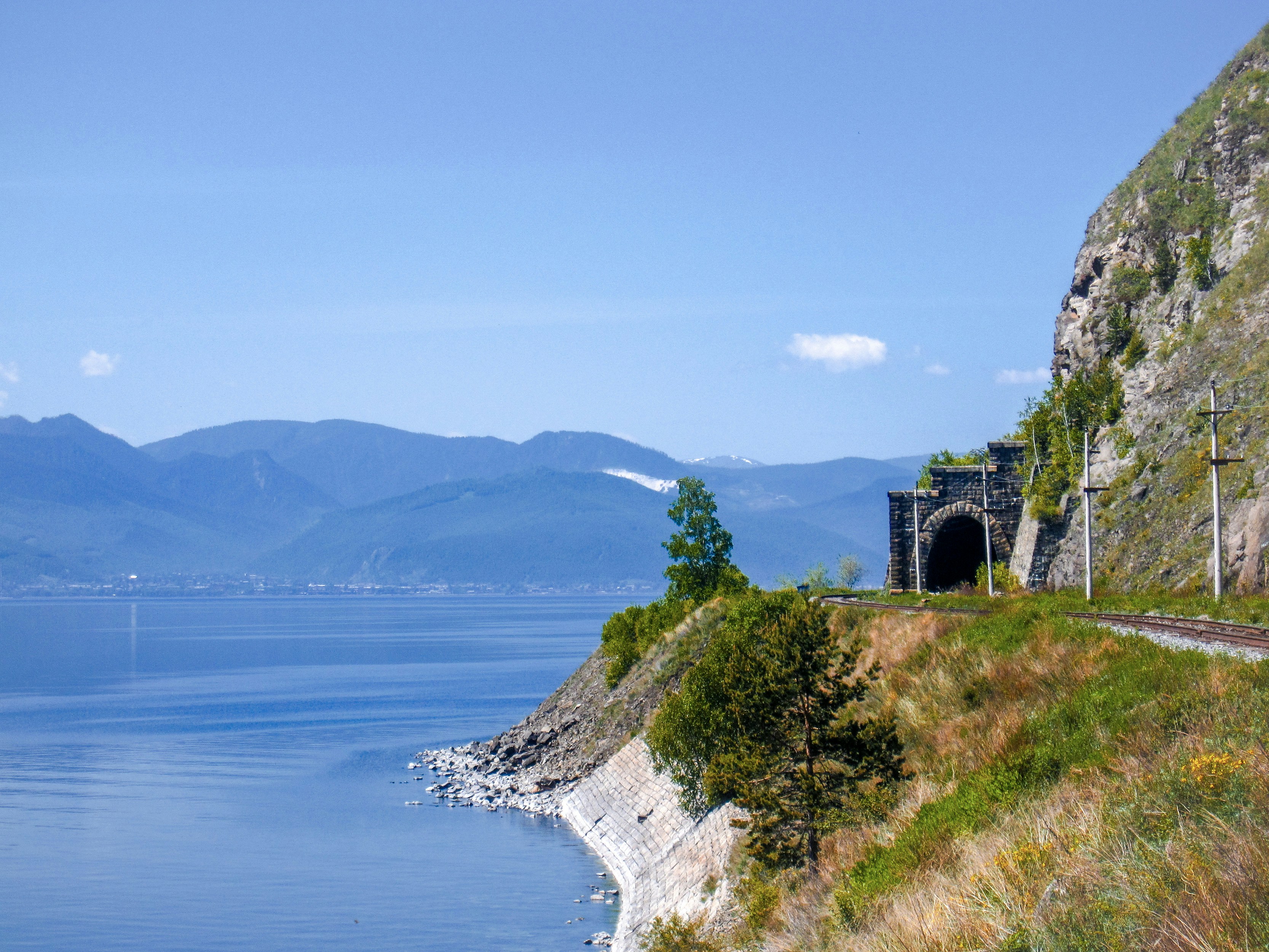 ein Zug auf einem Gleis neben einem Gewässer