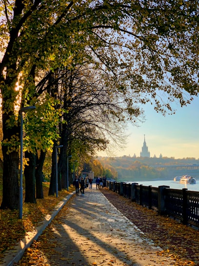 people walking down a path next to a river