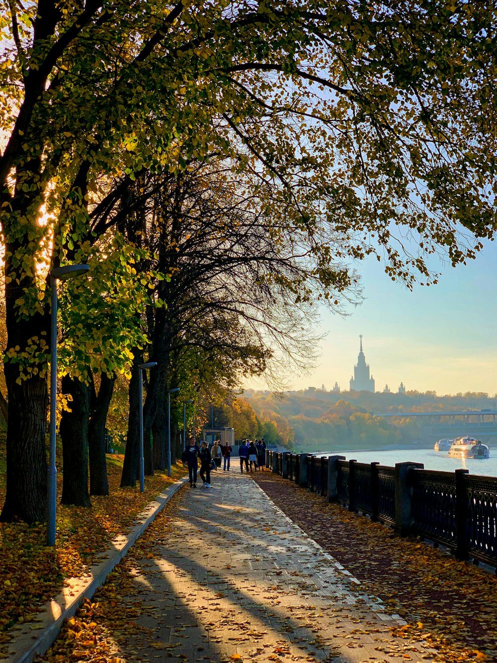 people walking down a path next to a river