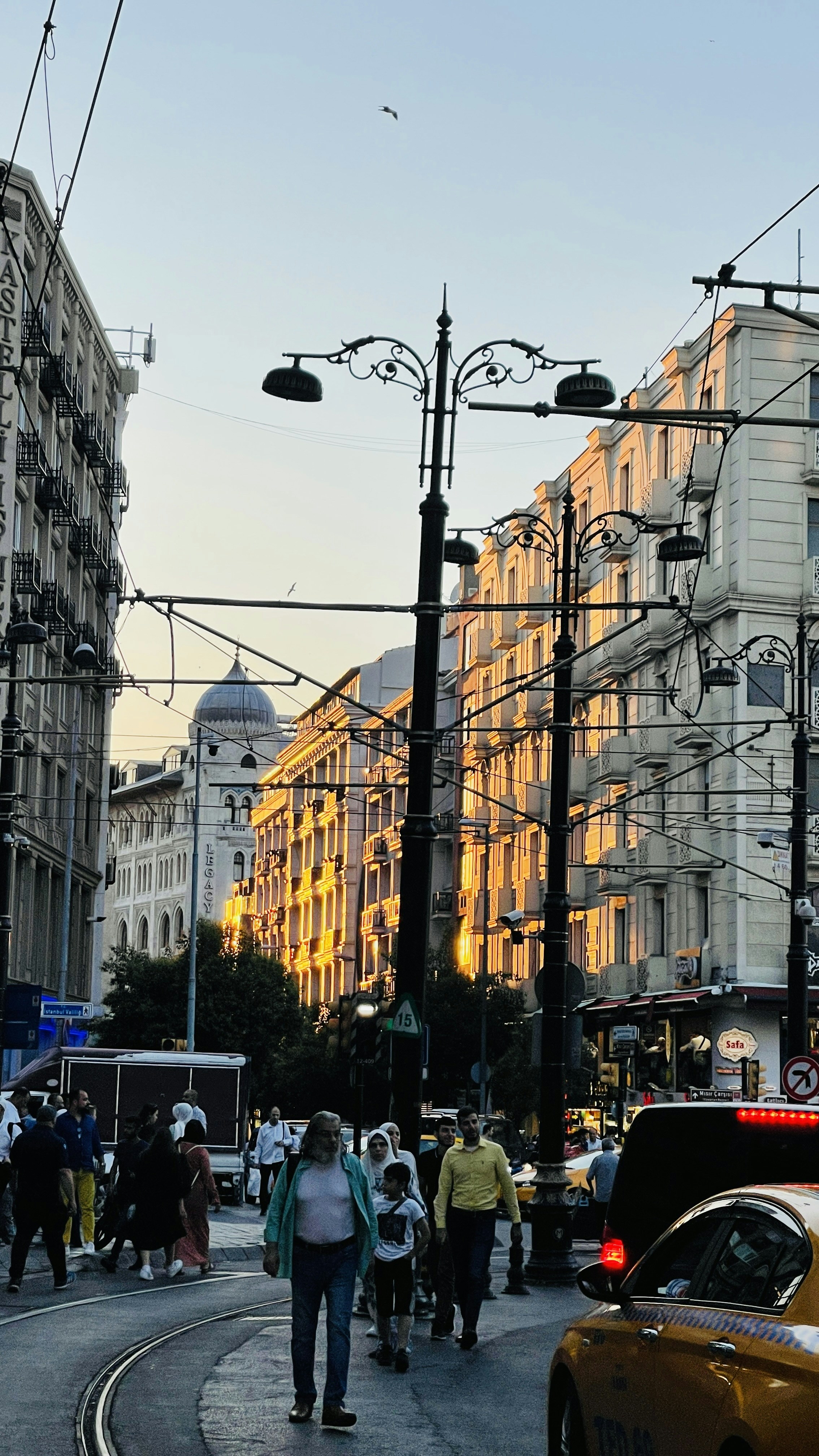 a group of people walking down a street next to tall buildings