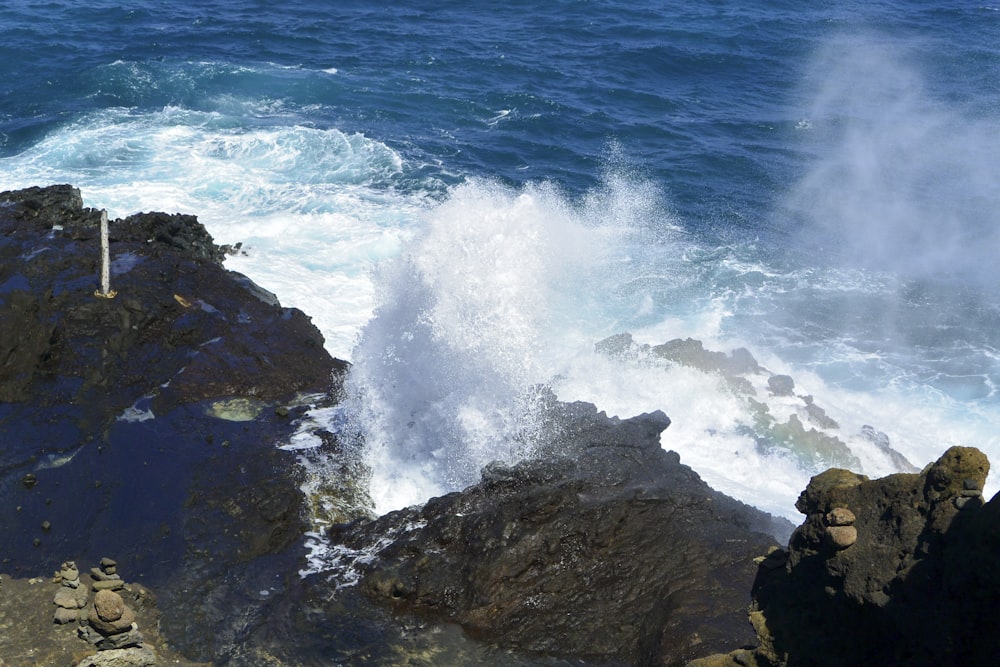 Uma onda cai nas rochas perto do oceano