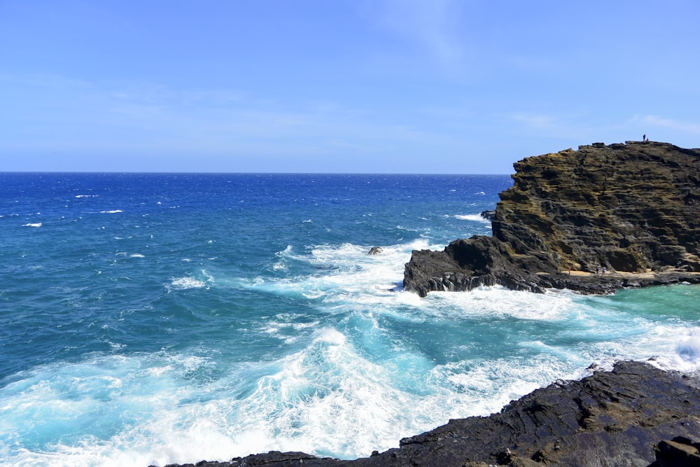 a large body of water next to a rocky cliff