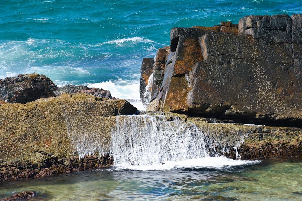 a small waterfall in the middle of the ocean