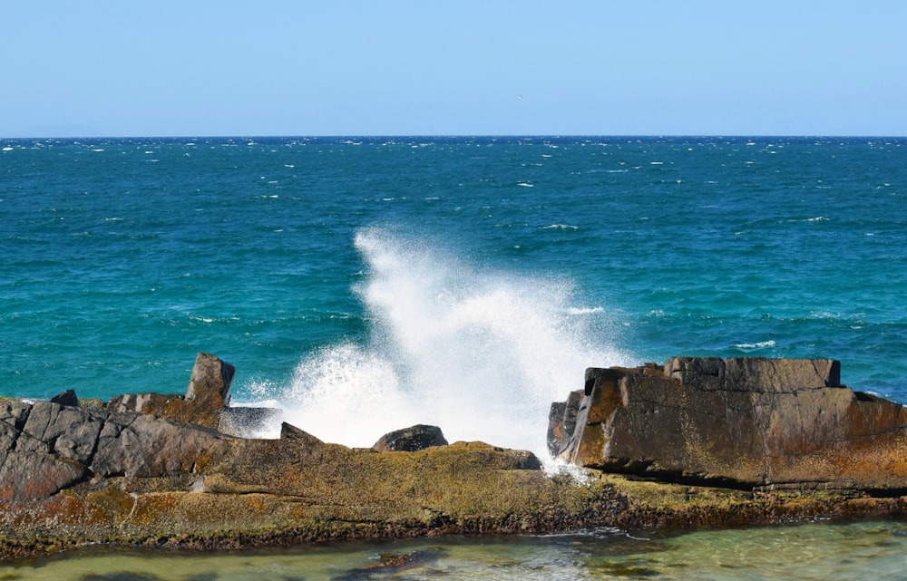 a wave crashing on rocks in the ocean