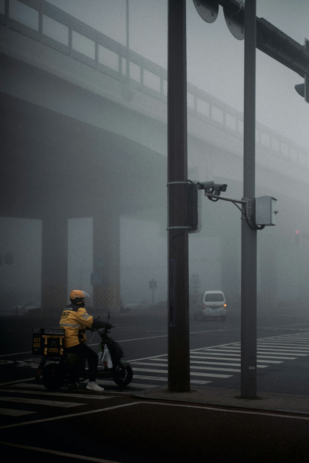 a person riding a motorcycle on a foggy street