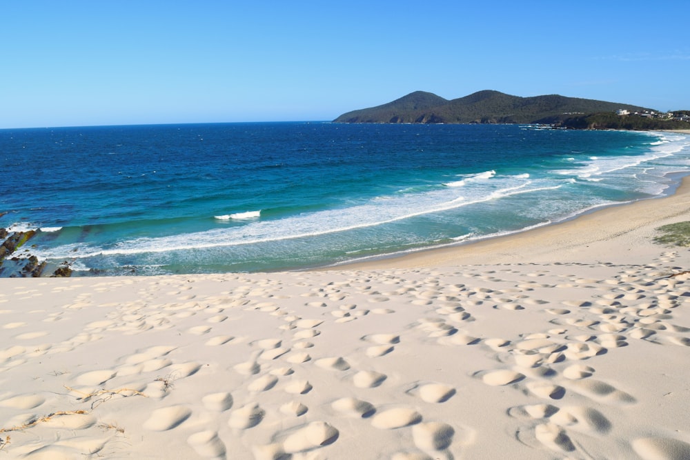 a sandy beach with footprints in the sand