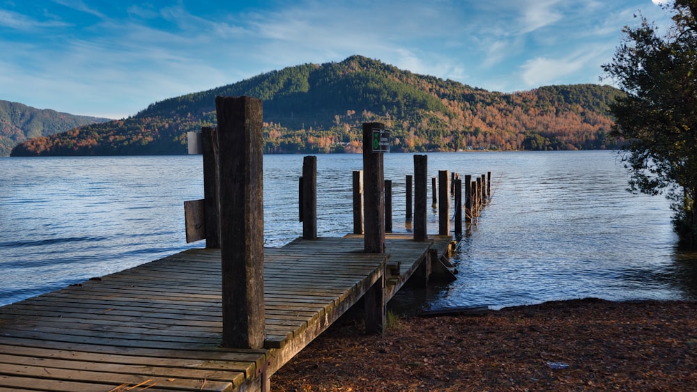 a wooden dock on a lake with mountains in the background