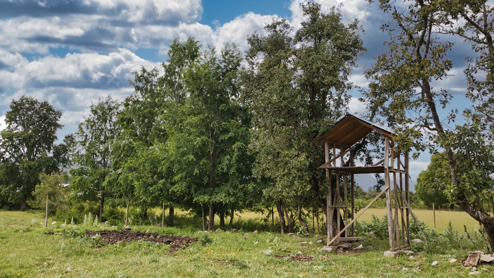 a small wooden structure in the middle of a field