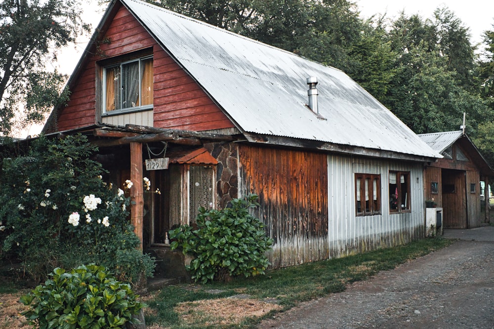 an old red and white house with a metal roof